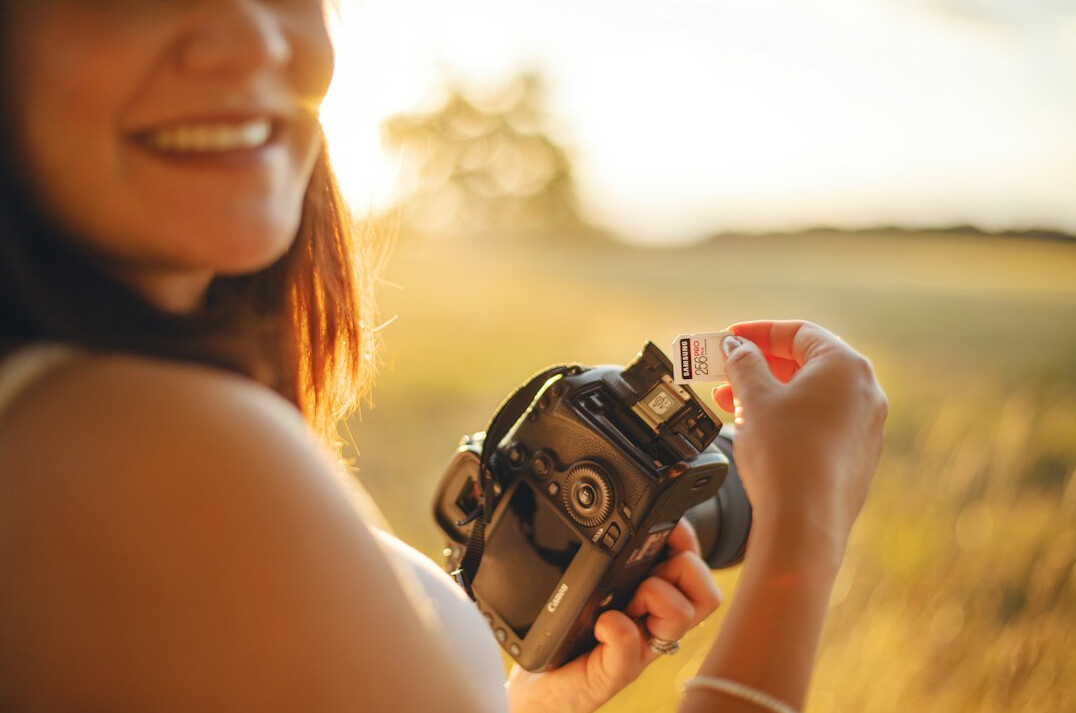 Young female photographer holding a camera and smiling