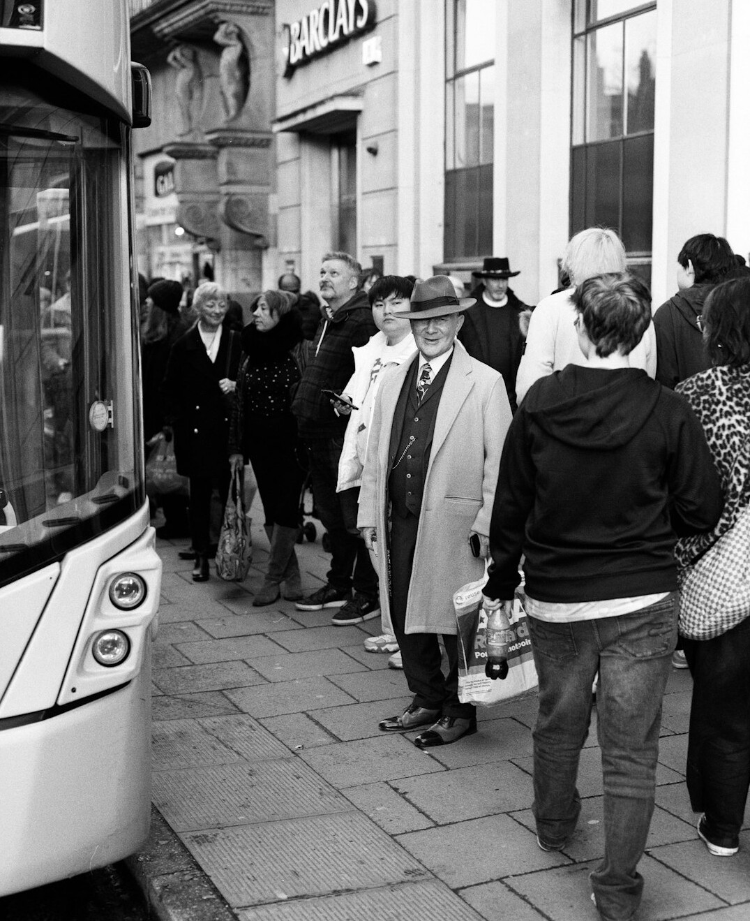 Elderly man in glasses waiting patiently in a queue